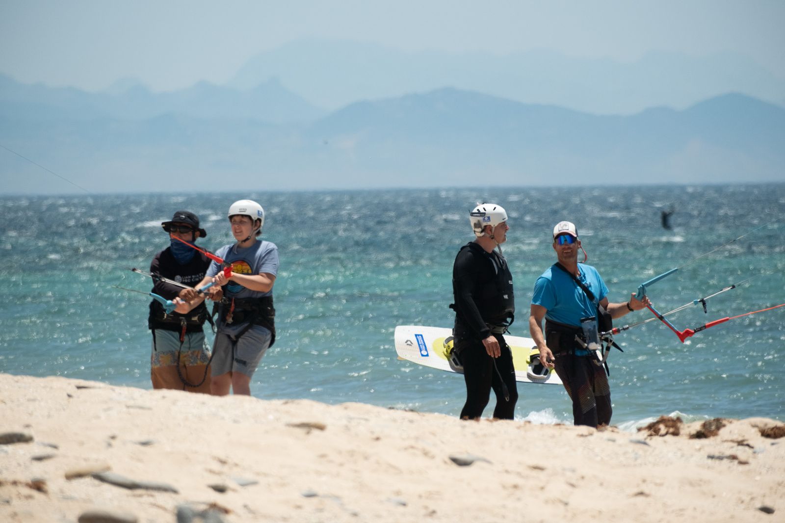 Private and semi-private kitesurf lessons taking place on the beach in Tarifa with instructors coaching beginner riders.