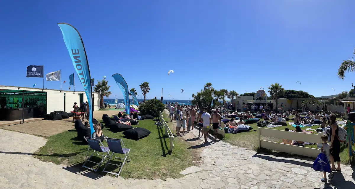 Valdevaqueros beach in Tarifa during peak period with kitesurfers, Duotone flags and social atmosphere
